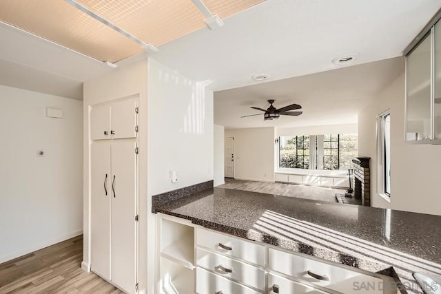 kitchen with white cabinets, ceiling fan, and light hardwood / wood-style floors