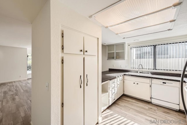 kitchen with dishwasher, white cabinetry, a wealth of natural light, and sink