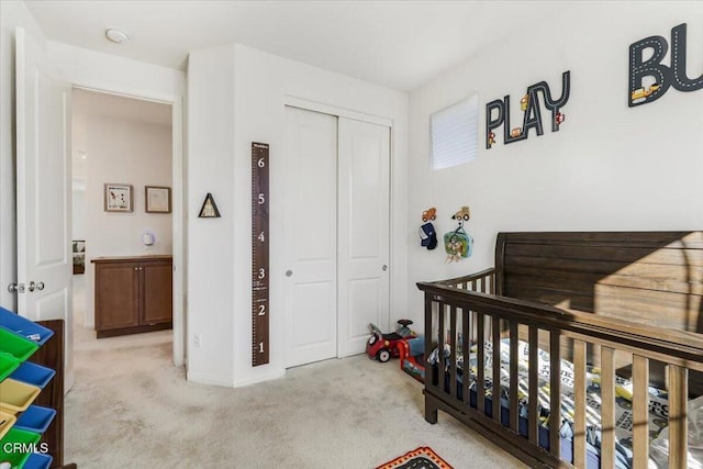 bedroom with light carpet, a closet, and a nursery area