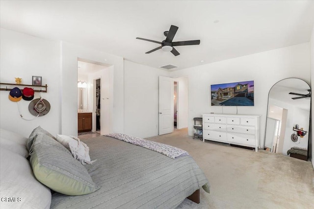 bedroom featuring connected bathroom, ceiling fan, and light colored carpet