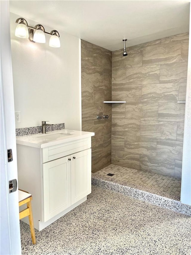 bathroom featuring vanity and tiled shower