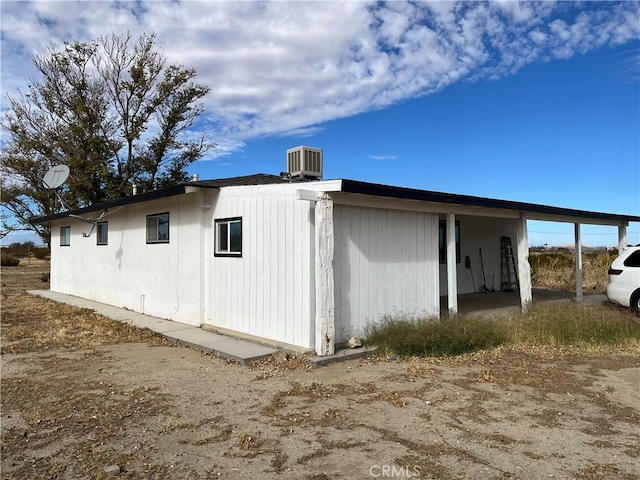 view of property exterior featuring central AC and a carport