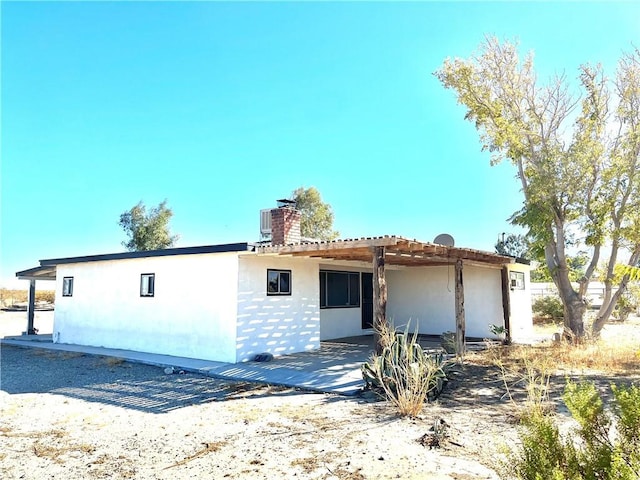 view of front of property featuring a pergola, a patio area, and central AC unit