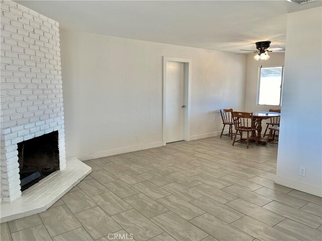 living room with a brick fireplace and ceiling fan