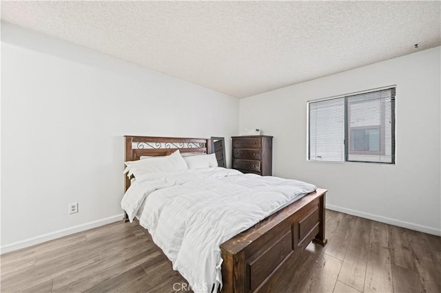 bedroom featuring wood-type flooring and a textured ceiling