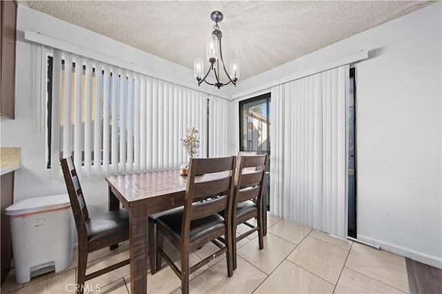 tiled dining room with a chandelier and a textured ceiling