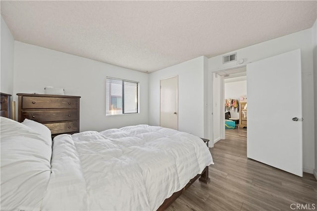 bedroom featuring dark wood-type flooring and a textured ceiling