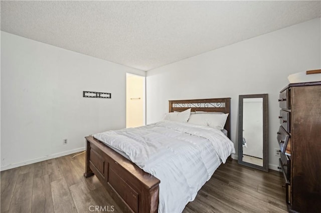 bedroom featuring dark hardwood / wood-style floors and a textured ceiling