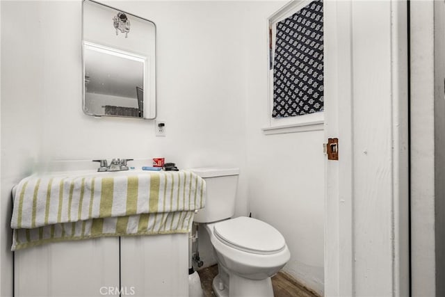 bathroom featuring hardwood / wood-style flooring and toilet