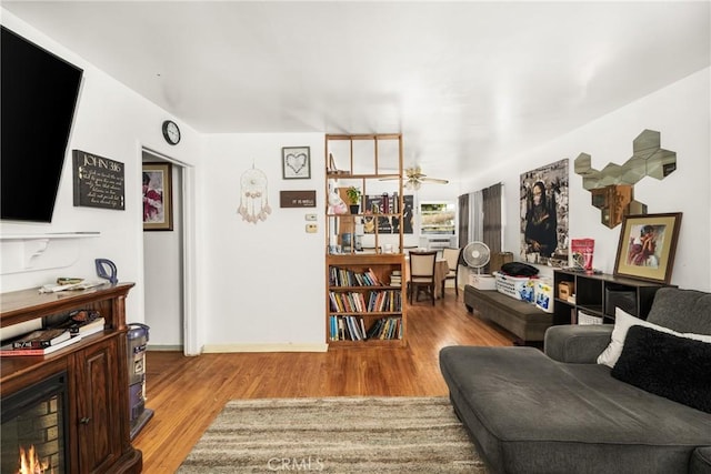 living room with light hardwood / wood-style flooring and ceiling fan