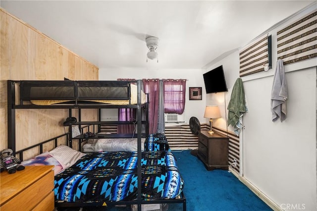 carpeted bedroom featuring wood walls, ceiling fan, and cooling unit