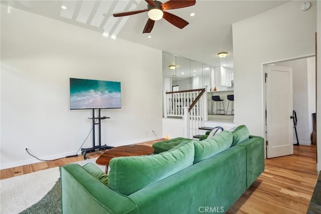 living room featuring light hardwood / wood-style flooring and ceiling fan