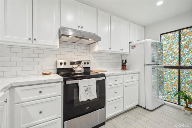 kitchen featuring backsplash, light stone counters, white refrigerator, white cabinets, and stainless steel electric range