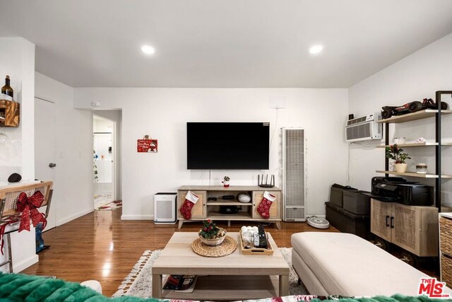 living room with a wall mounted AC and dark hardwood / wood-style floors