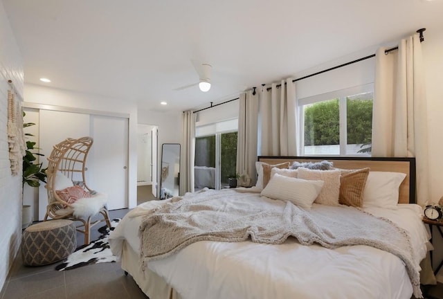 bedroom featuring a closet, dark tile patterned flooring, and ceiling fan