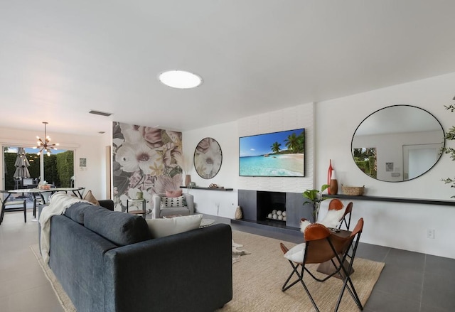 living room with a chandelier, tile patterned floors, and a fireplace