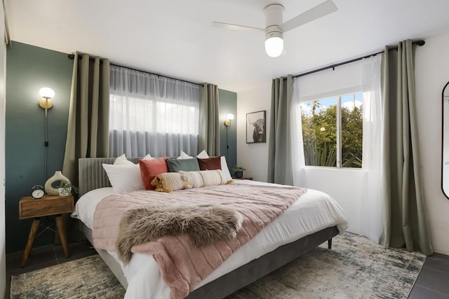 tiled bedroom featuring ceiling fan