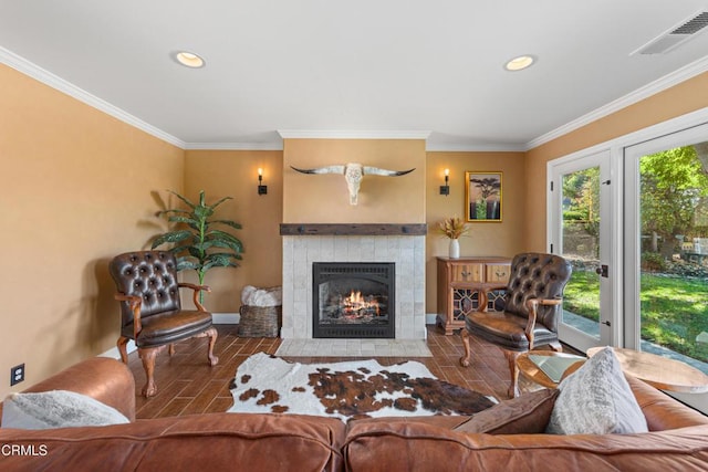 living room featuring a tile fireplace and crown molding