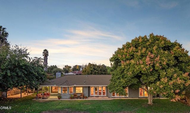 rear view of property with a yard, a patio area, and outdoor lounge area