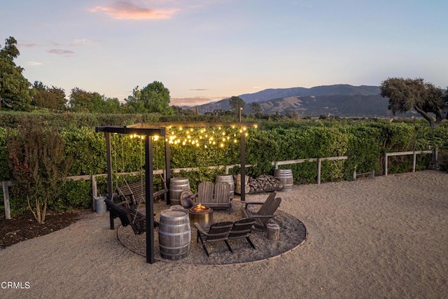 patio terrace at dusk with a mountain view and an outdoor fire pit