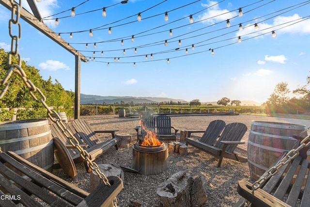 view of patio with a mountain view, a fire pit, and a rural view