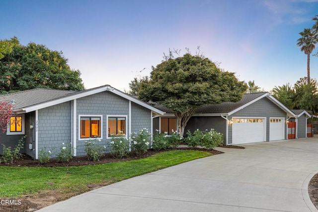 ranch-style home with a garage and a yard