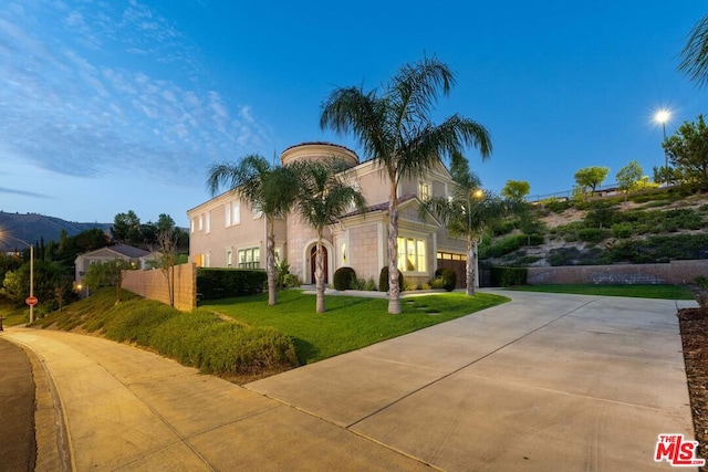 mediterranean / spanish home with a lawn and a garage