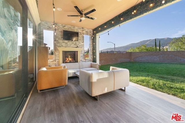 view of patio / terrace featuring an outdoor living space with a fireplace and ceiling fan