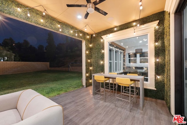 wooden terrace with ceiling fan and a yard