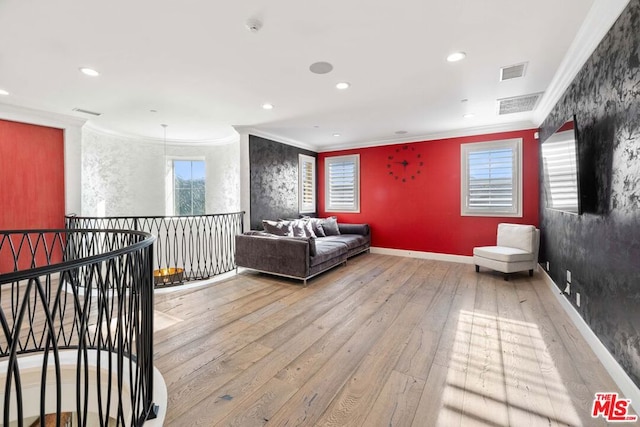 sitting room with a wealth of natural light, light hardwood / wood-style flooring, and ornamental molding