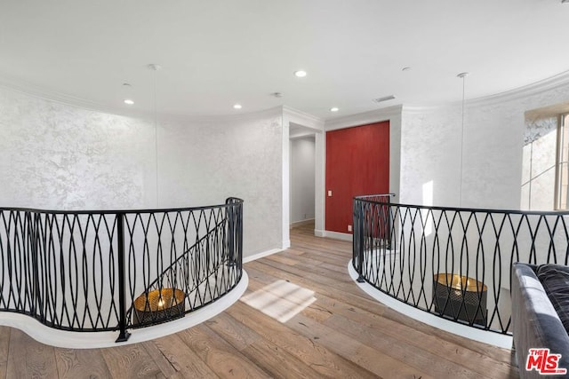 corridor featuring ornamental molding and hardwood / wood-style flooring