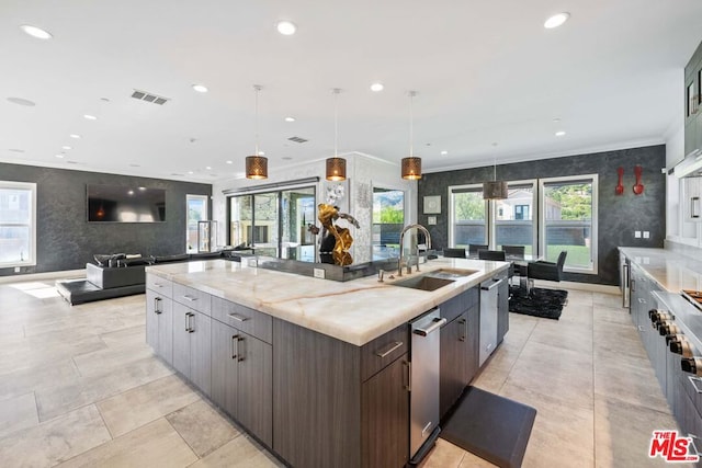 kitchen with hanging light fixtures, sink, a spacious island, and plenty of natural light