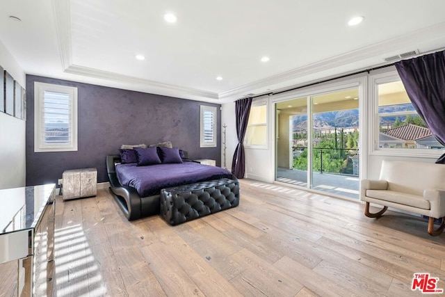 bedroom with access to outside, multiple windows, and light wood-type flooring