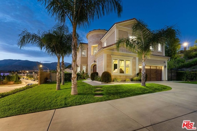 mediterranean / spanish house with a mountain view, a yard, and a garage