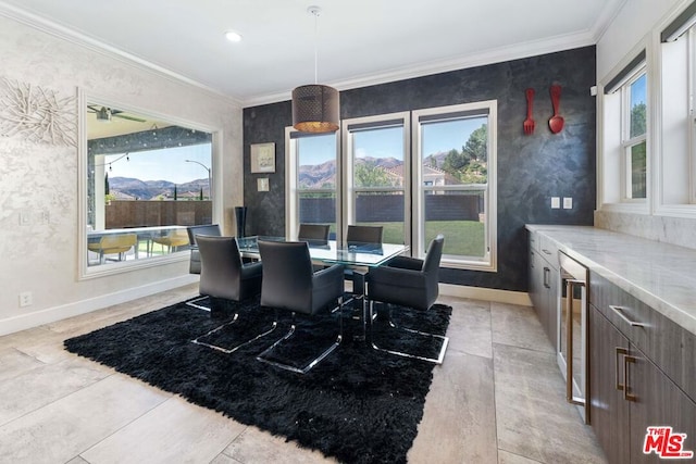 dining area with plenty of natural light, a mountain view, crown molding, and wine cooler