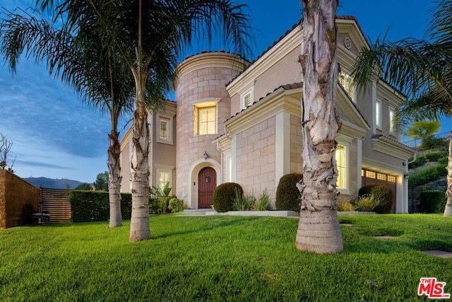 view of front of house with a garage and a front lawn