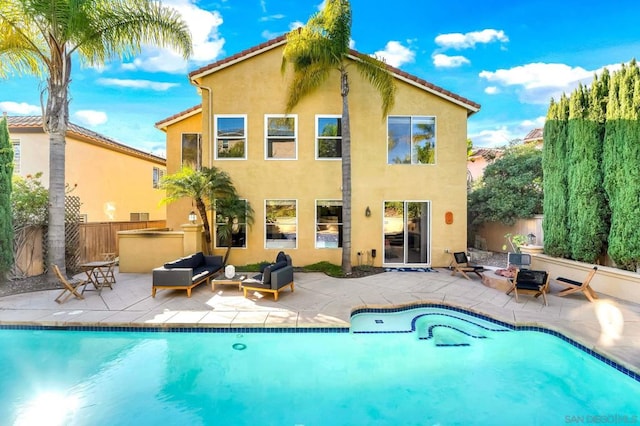 back of property with a patio area and an outdoor living space with a fire pit