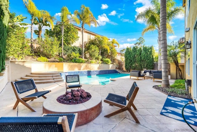 view of pool with a patio and an outdoor living space with a fire pit