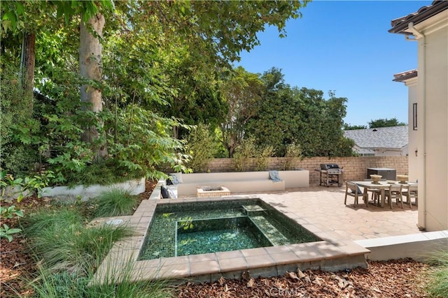 exterior space featuring a patio and an in ground hot tub