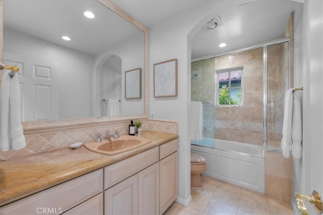 full bathroom with shower / bath combination with glass door, tile patterned flooring, backsplash, vanity, and toilet