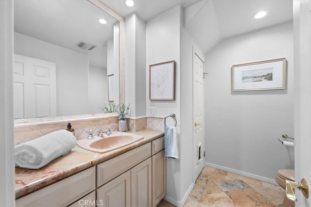 bathroom with vanity, toilet, and vaulted ceiling