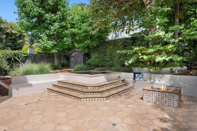 view of patio featuring a storage unit and an outdoor fire pit