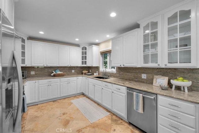 kitchen featuring light stone countertops, white cabinetry, appliances with stainless steel finishes, and sink