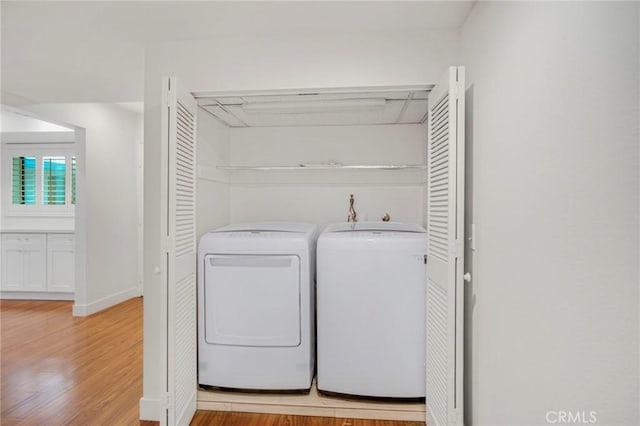 washroom with independent washer and dryer and light wood-type flooring