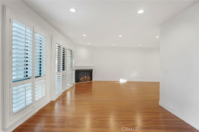 unfurnished living room with wood-type flooring and a wealth of natural light