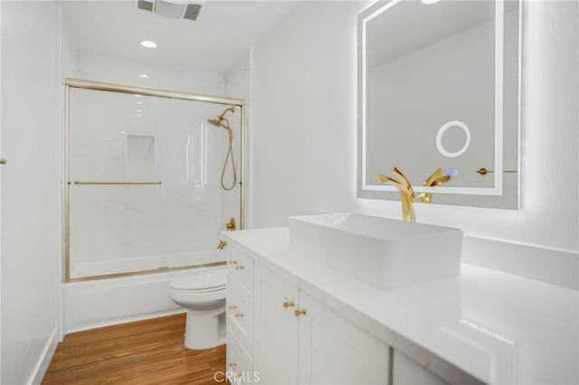 full bathroom featuring hardwood / wood-style flooring, vanity, toilet, and washtub / shower combination