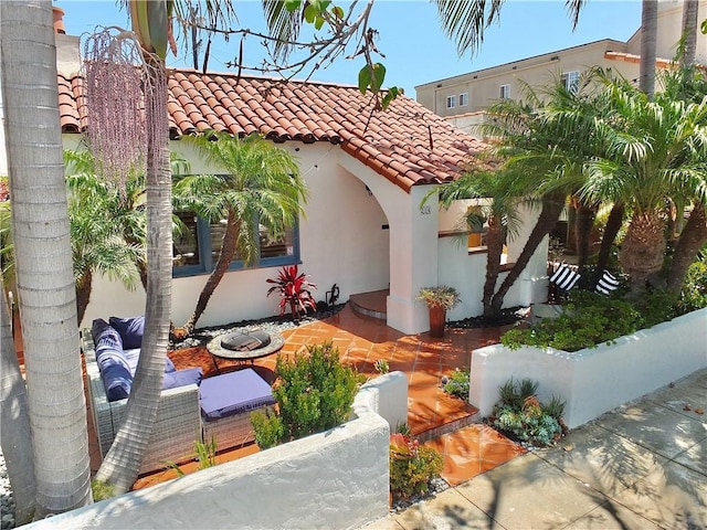 mediterranean / spanish-style house with a fire pit and a patio