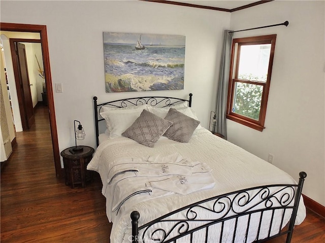 bedroom with dark hardwood / wood-style floors and ornamental molding