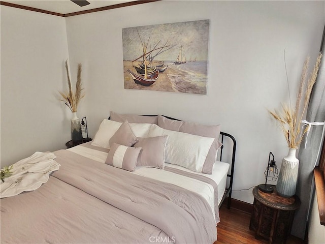 bedroom with dark hardwood / wood-style flooring and ornamental molding