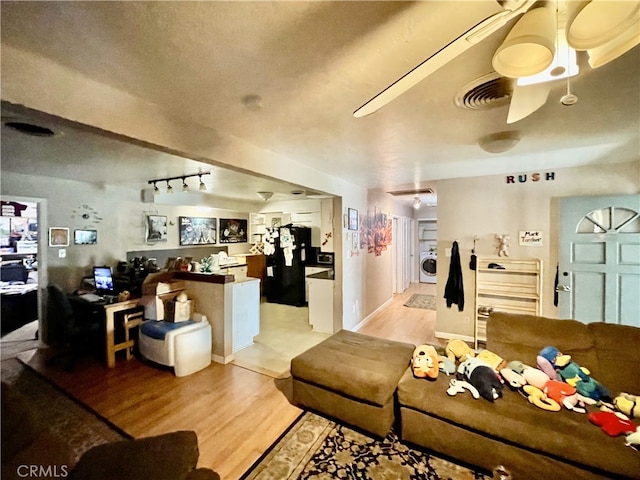 living room featuring washer / clothes dryer and light wood-type flooring